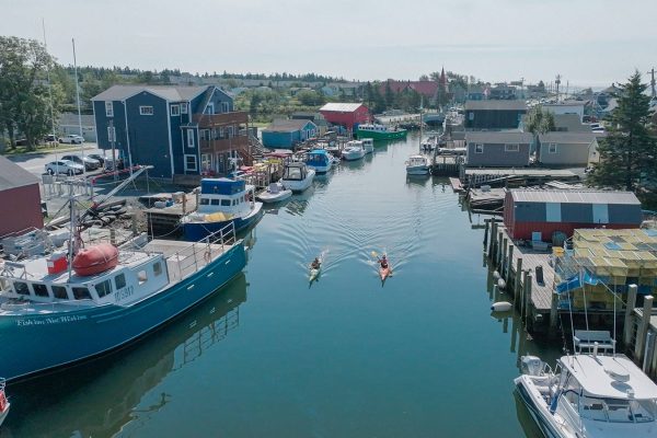 Aerial view of a Nova Scotia fishing village and harbour featured in Oceanfront Property Hunt