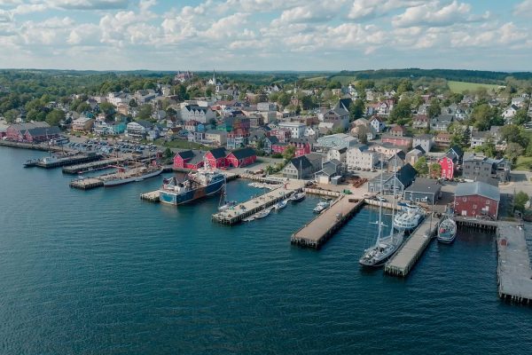 Aerial view of a colourful Nova Scotia waterfront town and harbour featured in Oceanfront Property Hunt